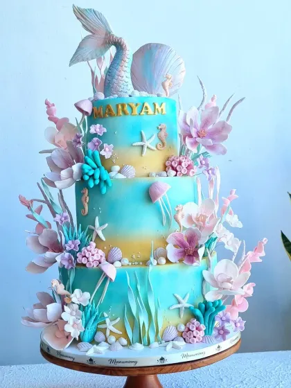 A full shot of the three-tiered mermaid cake, showcasing its vibrant colors and detailed decorations.