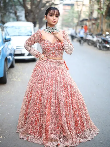 A stunning pink and silver lehenga with a full, flowing skirt and detailed embroidery, perfect for making a grand entrance.