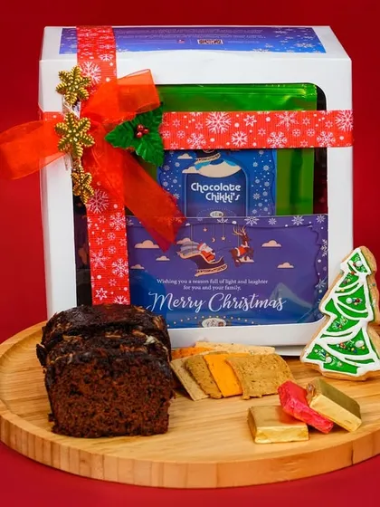 Our Christmas gift hampers are curated to deliver joy. This beautifully packaged 'Merry' hamper includes our classic plum cake, festive cookies, and other treats, making it the perfect holiday gift for friends and family.