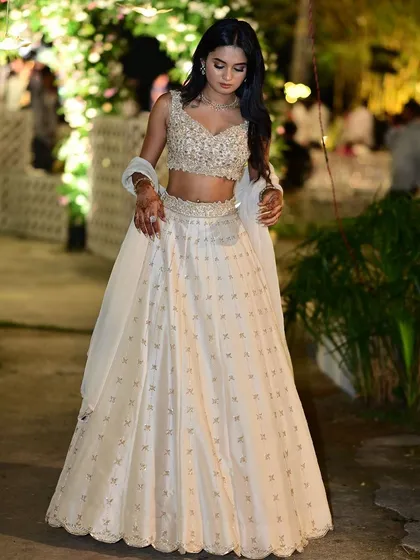 The same client looking radiant in her ivory lehenga, a perfect choice for an evening celebration.