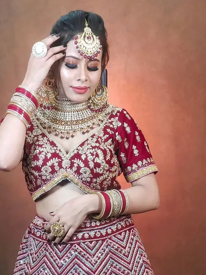 This maroon velvet lehenga features a modern chevron pattern on the skirt, blending traditional colour with contemporary design. The full look is available for rent.