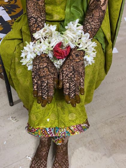 More views of Fathima's bridal henna, showing the personalized name and the stunning floral jewelry that completes the look.