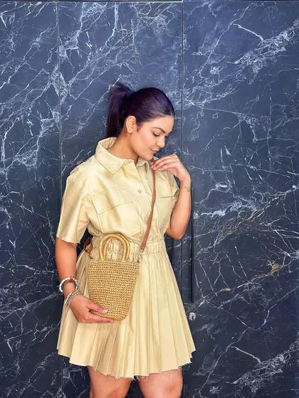 This pose shows the bag from the side, highlighting its simple yet chic silhouette and how it complements the neutral tones of the outfit.