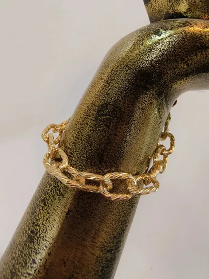 A close-up of the anti-tarnish chain link bracelet, worn on a display to show its texture.