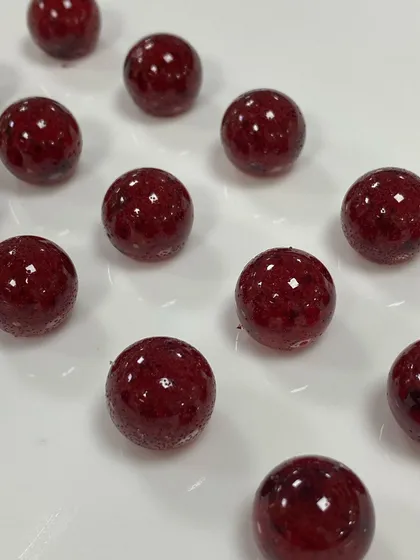 Another look at our all natural cranberry caramelised pearls. The deep red colour comes entirely from the fruit itself, highlighting our commitment to creating specialty ingredients without artificial additives.