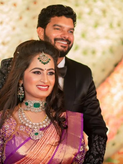 A happy, smiling portrait of the couple. Sushma's makeup is radiant and joyful, perfect for her reception.