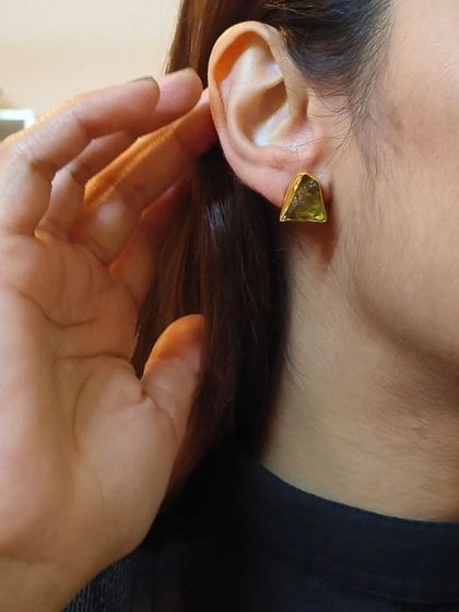 A simple yet elegant look with these triangular green stone studs, plated in gold for a premium finish.
