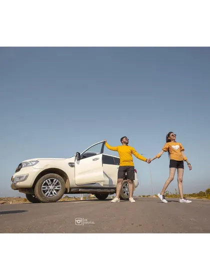 A wide shot capturing the feeling of a road trip and adventure. Using a car as a prop can help tell a story of your journey together.