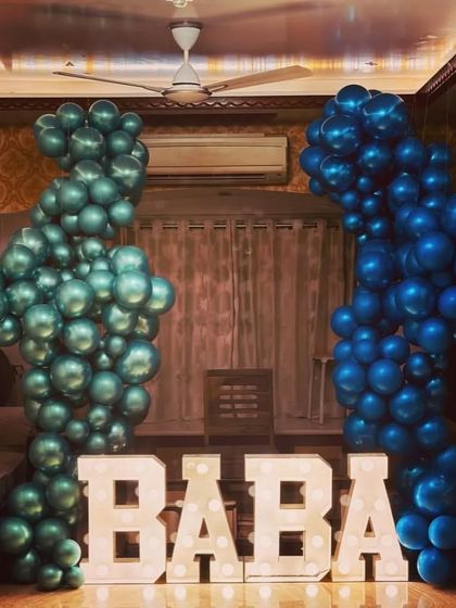 Custom light-up marquee letters are a great way to personalize any event. For this party, we spelled out "BABA" and framed it with two-tone blue balloon columns for a heartfelt and unique decoration.