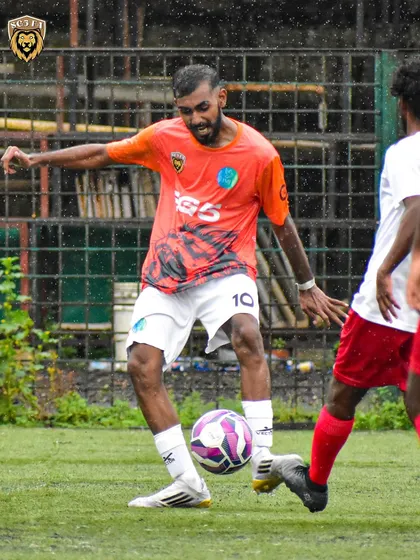 A player showing precise ball control in the rain. We train our players to adapt and perform in all conditions.