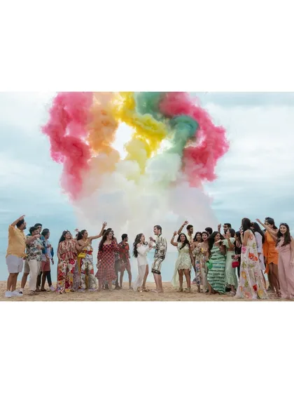 A burst of rainbow-colored smoke on the beach creates a stunning backdrop for this group celebration. It’s a vibrant and energetic moment that perfectly captures the spirit of a destination wedding party.