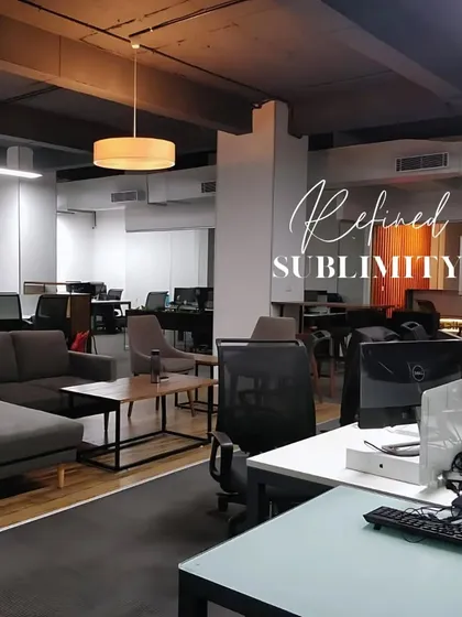 A refined and sublime office interior. The design uses a dark, exposed ceiling and a mix of task and ambient lighting to create a modern, industrial-chic workspace.