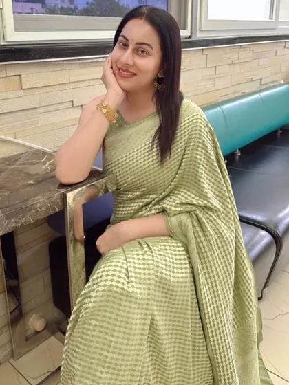A relaxed and happy portrait of Dr. Shruthi, her pastel Banarasi saree looking effortlessly elegant.