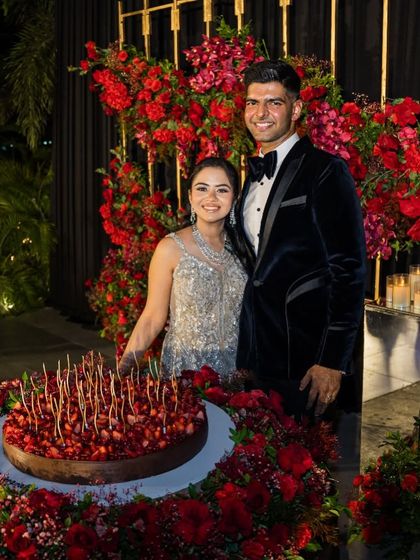 Standing proudly with my husband next to the wedding cake I designed. It was a massive chocolate and berry creation that truly represented our story.