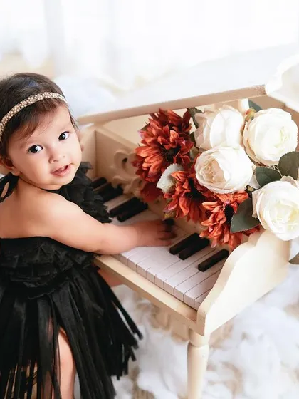 A sweet look back at the camera. The black dress and classic props give this milestone photo a timeless, glamorous feel.