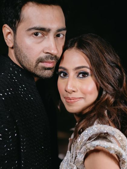 A close-up of the couple. The subtle blue shimmer on her eyes ties in with the details on her lehenga.