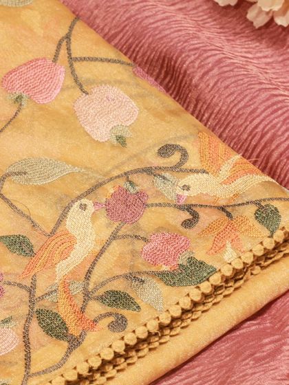 A close-up of the intricate Paithani embroidery on the sheer tissue silk fabric.