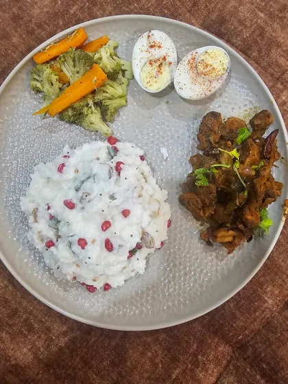Here's another satisfying meal: chicken, hard-boiled eggs, pomegranate curd rice, and steamed vegetables. Variety is crucial for a sustainable diet.