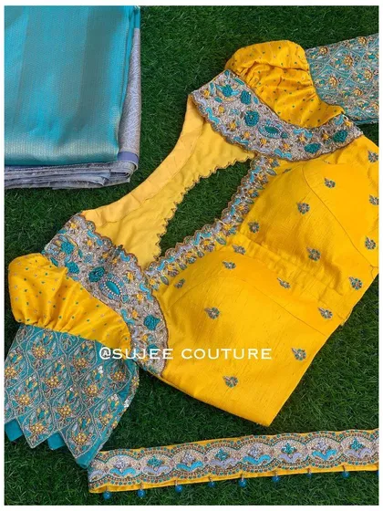 A flat-lay of the yellow and teal blouse set. This includes the blouse, the unstitched saree fabric, and an embroidered border, showing how all the components are designed to work together.