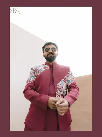 A confident portrait of the groom, Tirth, showcasing the detailed embroidery on his stylish jacket.