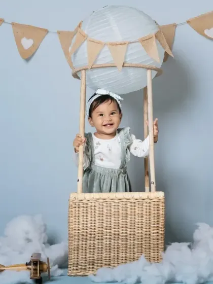 A full setup of the hot air balloon theme, complete with fluffy clouds and a toy airplane.