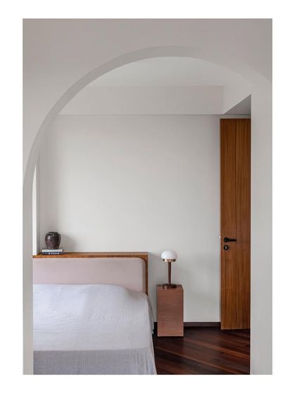 A view into the bedroom, where an archway frames the custom wardrobe and desk I designed. This architectural framing creates a sense of a separate, dedicated zone for work and storage.