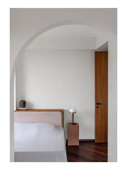 A view into the bedroom, where an archway frames the custom wardrobe and desk I designed. This architectural framing creates a sense of a separate, dedicated zone for work and storage.