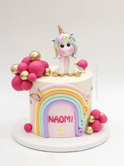 A clean, studio shot of the unicorn and rainbow cake.
