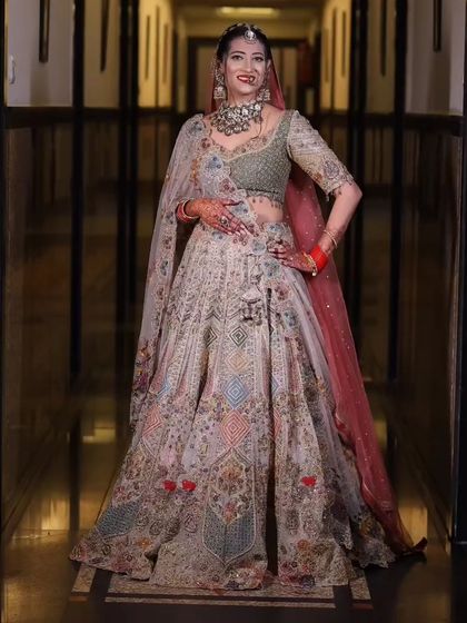 Another full-length shot of the bride, showing off the beautiful drape of her lehenga and her confident pose.