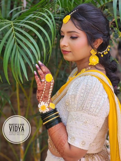 Priya looking serene and beautiful for her haldi ceremony. The natural setting complements her fresh and vibrant look.