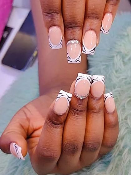 A fun take on the French manicure with a zebra-print tip and a line of crystals at the base.
