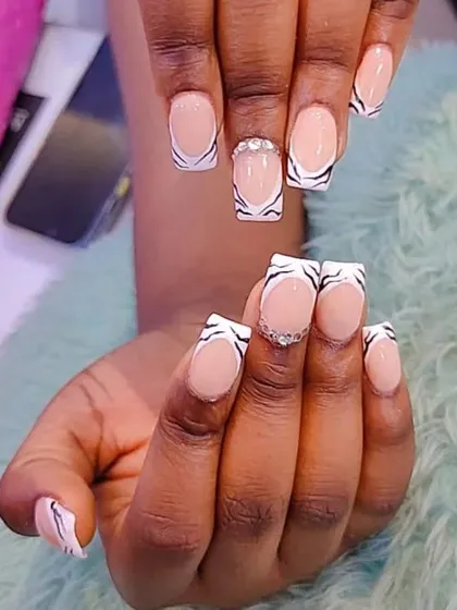 A modern take on the French manicure with a zebra print tip. The black and white pattern on the square-shaped nails is accented with a line of crystals for extra sparkle.