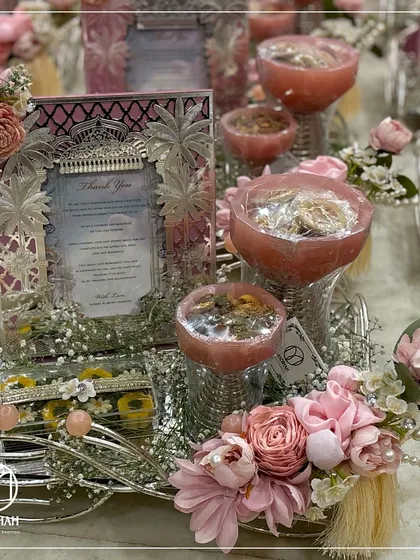 A symbol of gratitude for your wedding guests. This pastel pink hamper, featuring dry fruit bowls and a silver frame for a thank you note, is designed to leave a lasting impression of your special day.