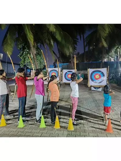 Students line up for their turn to shoot during a summer camp evening session.