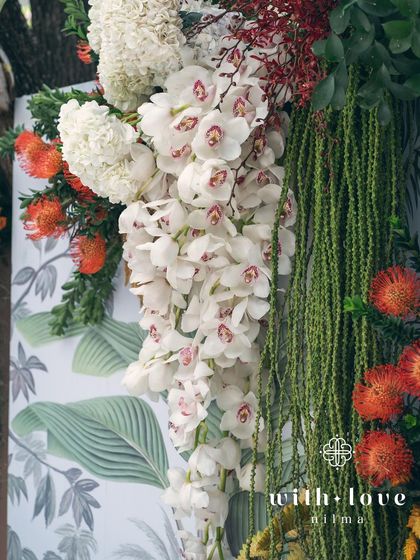 A close-up of the cascading white orchids against the botanical print backdrop of the 'Garden of Gaia' design.