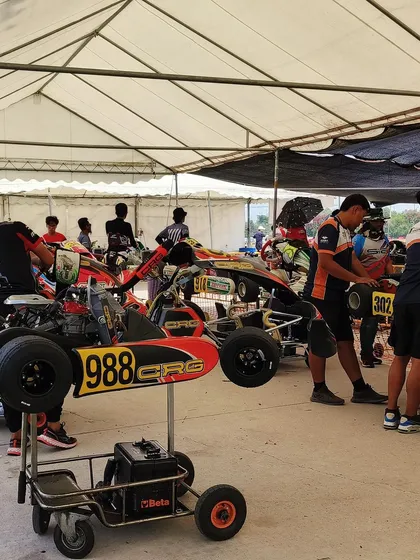 The pit area at an international race, with various teams preparing their karts.