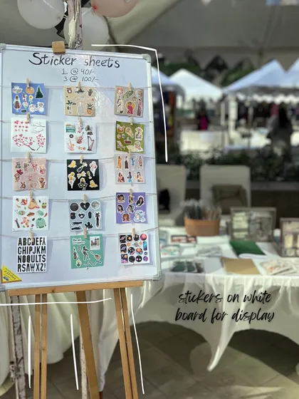 My sticker sheets on display at a pop-up store. Seeing my products out in the world and meeting customers is one of the best parts of running this business.