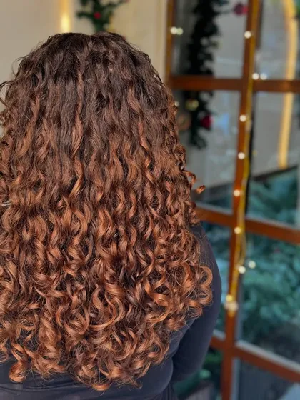 Getting clients ready for the holidays with a festive hair color. This warm-toned balayage was done without bleach, making it the perfect gift for healthy curls.