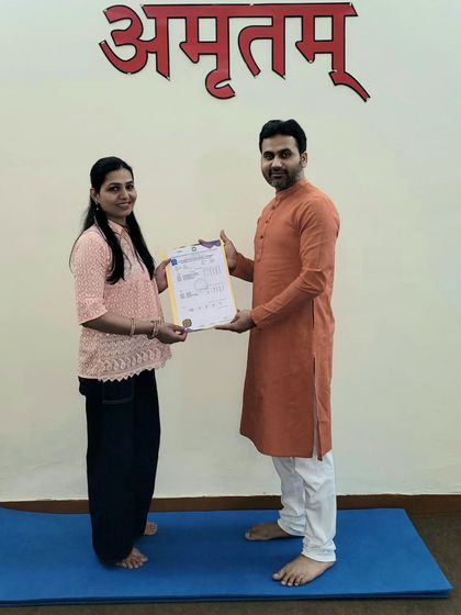 Presenting a certificate of completion for our yoga teacher training course. We celebrate every student's unique journey and achievement.