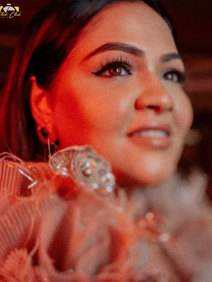 A beautiful solo portrait of Saloni, glowing in the warm, red light of her sangeet night.