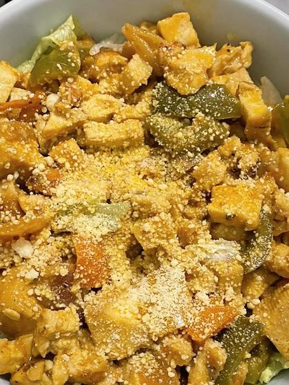 A client's bowl of sautéed chicken and vegetables, sprinkled with nutritional yeast for extra flavor and B vitamins.