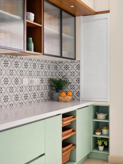 A detail of the 'Garden of Eden' kitchen, showing the corner storage solutions, pull-out baskets, and a rolling shutter unit to conceal appliances.