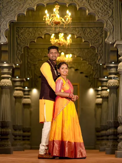 Posing in a grand, well-lit hall, this couple's traditional outfits shine. This location is perfect for creating a regal pre-wedding album.