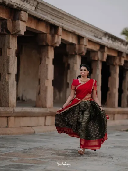 A beautiful solo portrait of the bride-to-be walking through a temple corridor, her traditional skirt in full twirl.