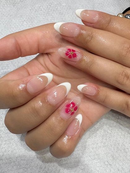 A closer look at the final result of the floral French manicure, showing the delicate, hand-painted flower with a tiny gold stud in the center.