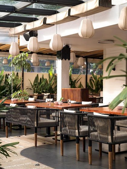 I believe a restaurant should feel like an escape. For this heritage bungalow project, I designed an outdoor seating area with a retractable pergola, lush greenery, and custom banana fiber lights to create a refreshing, tropical ambiance day and night.