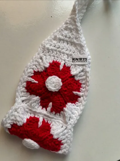 The red and white flower power bandana, showing the "Knots by Anshuka" brand tag. It's a fun, retro-inspired hair accessory.