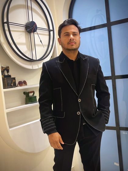 A client wearing the black jacket with contrast white stitching. This simple detail elevates a classic black suit into a custom-designed piece.