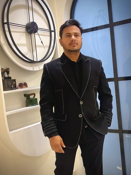 A client wearing the black jacket with contrast white stitching. This simple detail elevates a classic black suit into a custom-designed piece.
