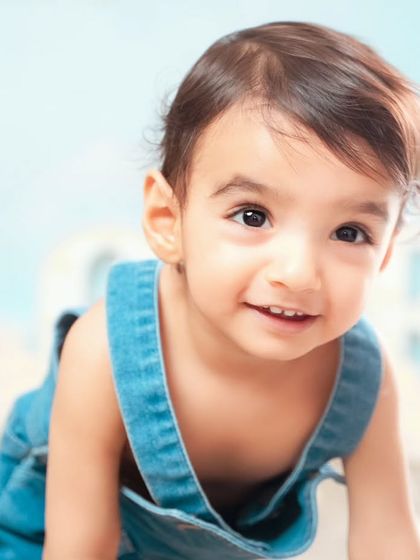 A close-up shot of a baby boy with a charming smile during his hot air balloon themed shoot.